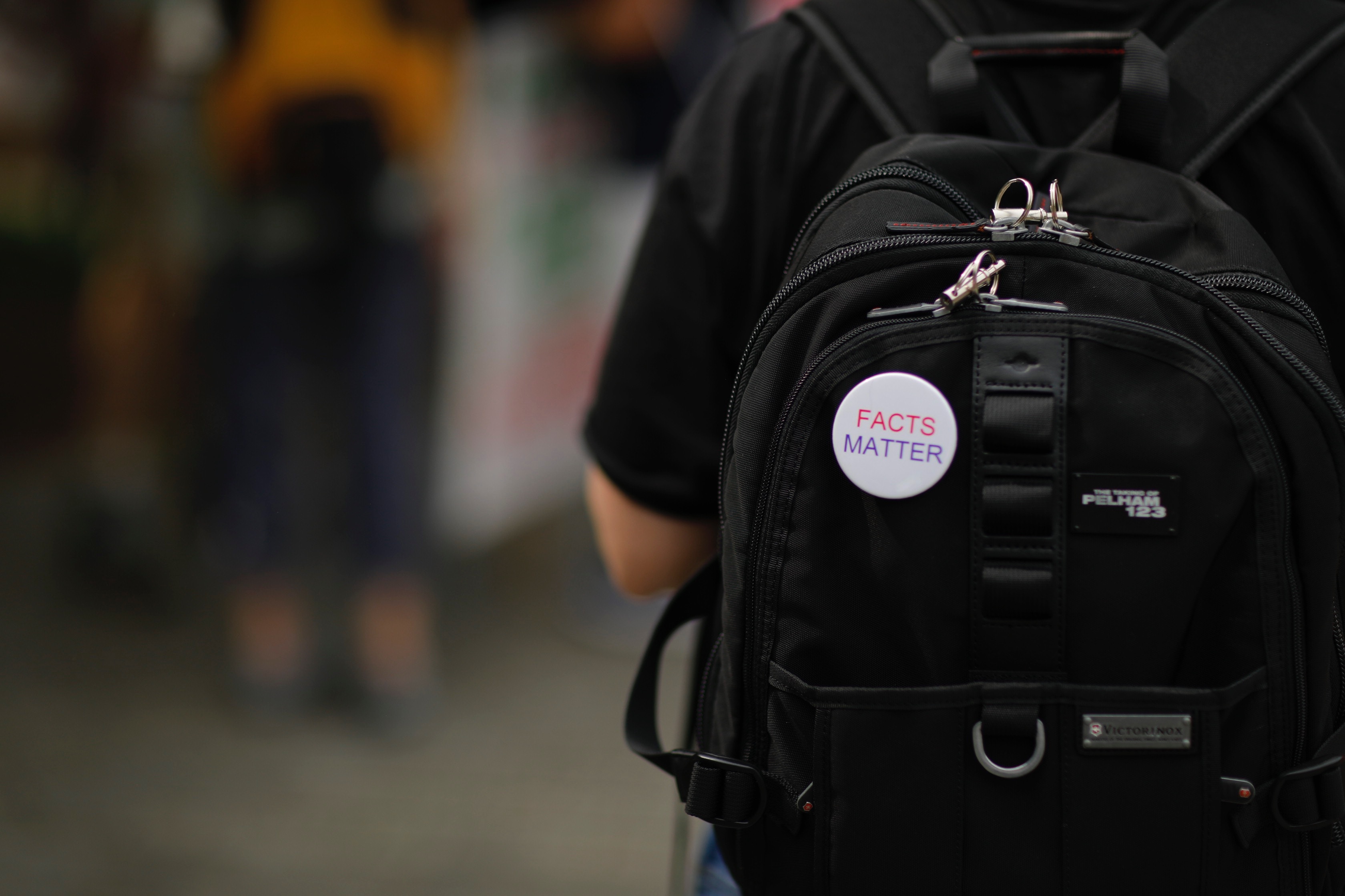 Backpack with pin on it saying "Facts Matter"