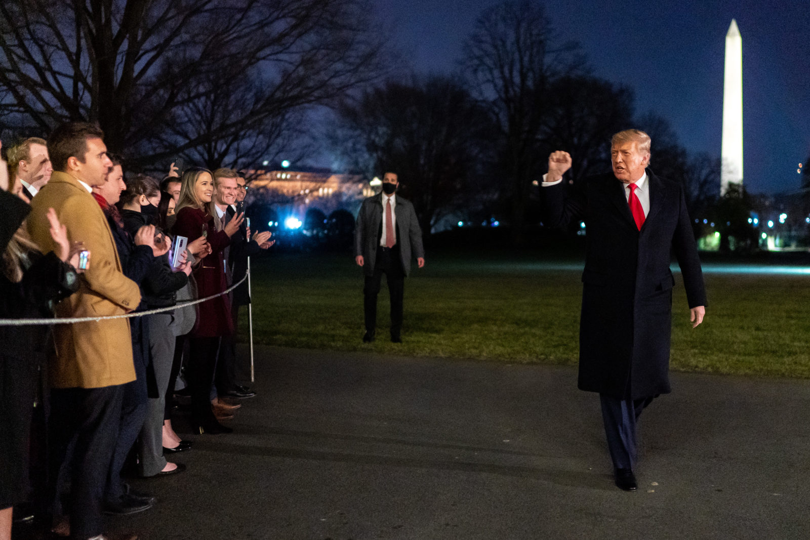 President Donald J. Trump gestures to White House staff with a fist pump after disembarking Marine One on the South Lawn of the White House Tuesday, Jan. 12, 2021, following his trip to Texas.