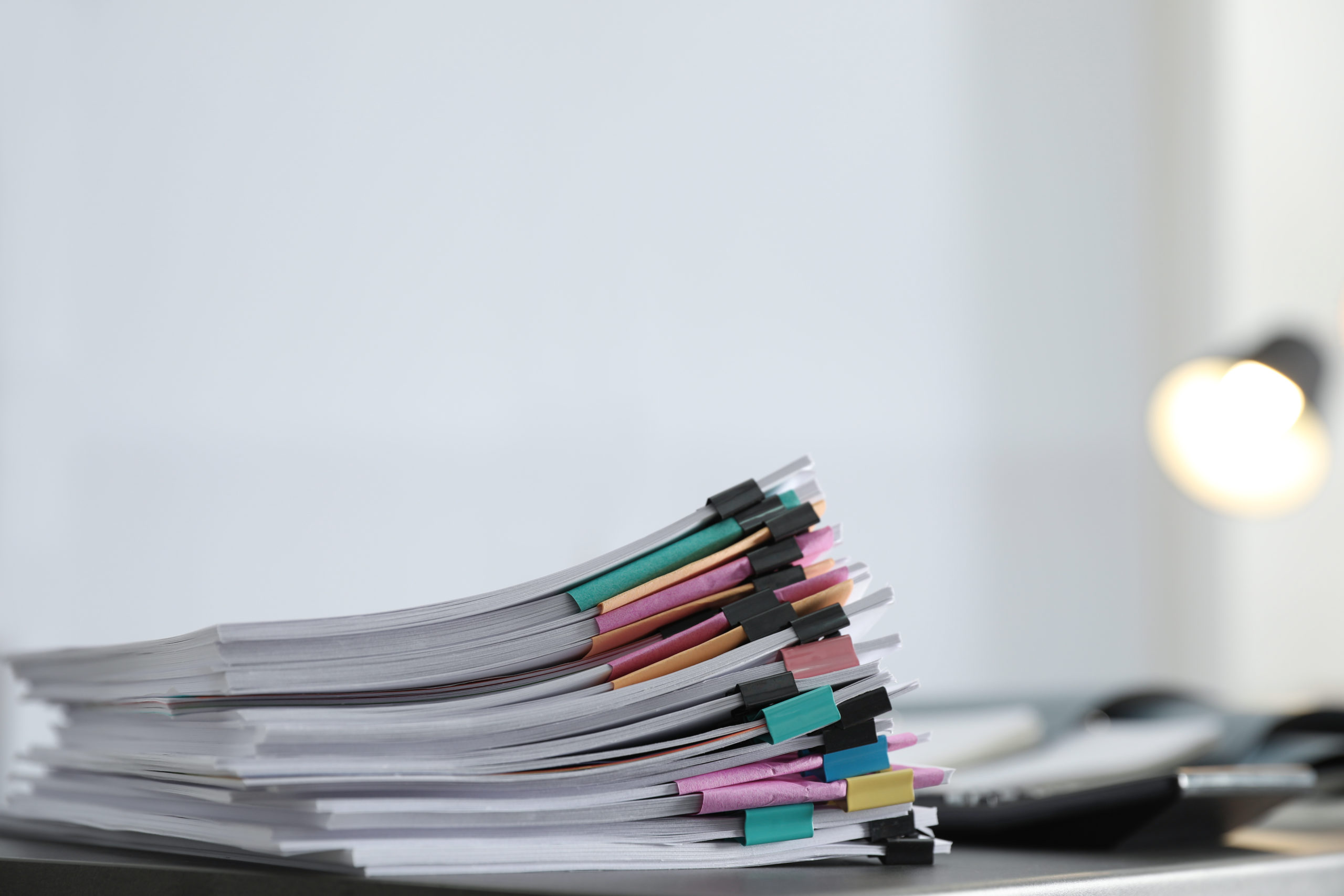 Stack of documents with paper clips on office table. Space for text