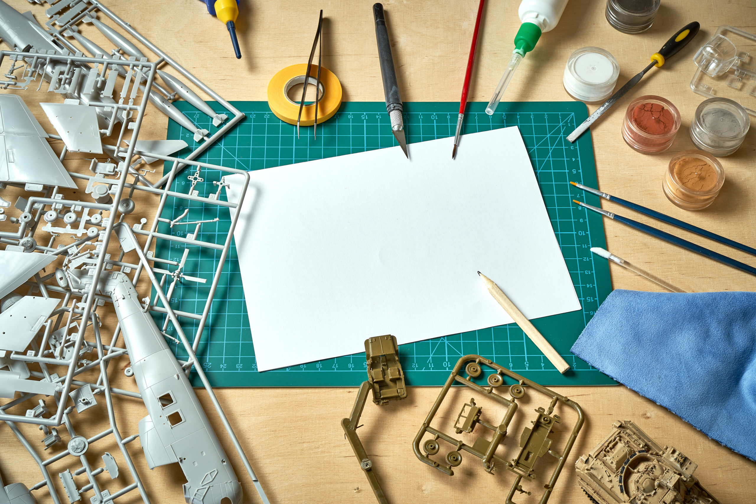 Top view on plastic model scale with accessories on  green pad on  wooden table