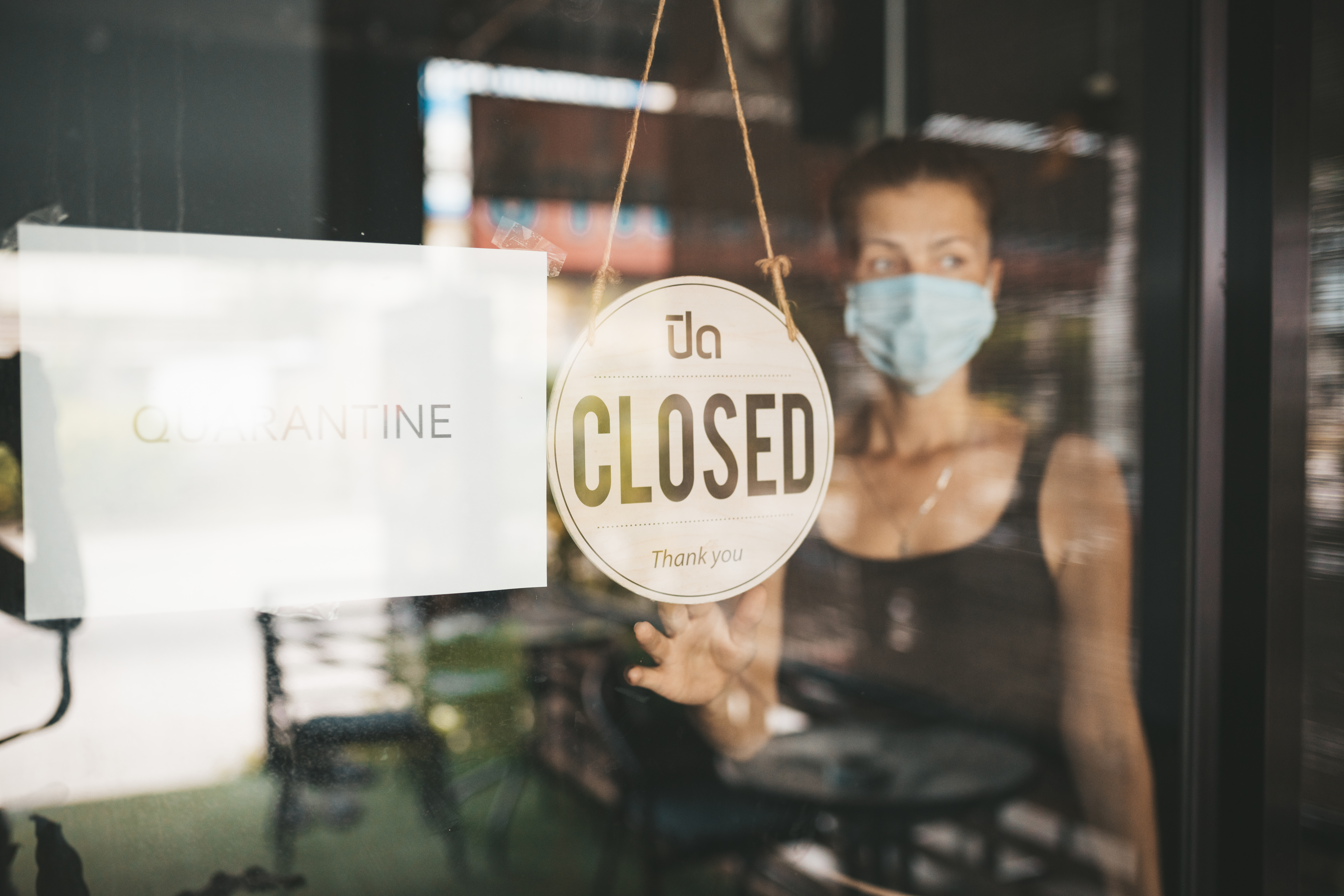 Store Owner in medical mask closed restaurant for quarantine