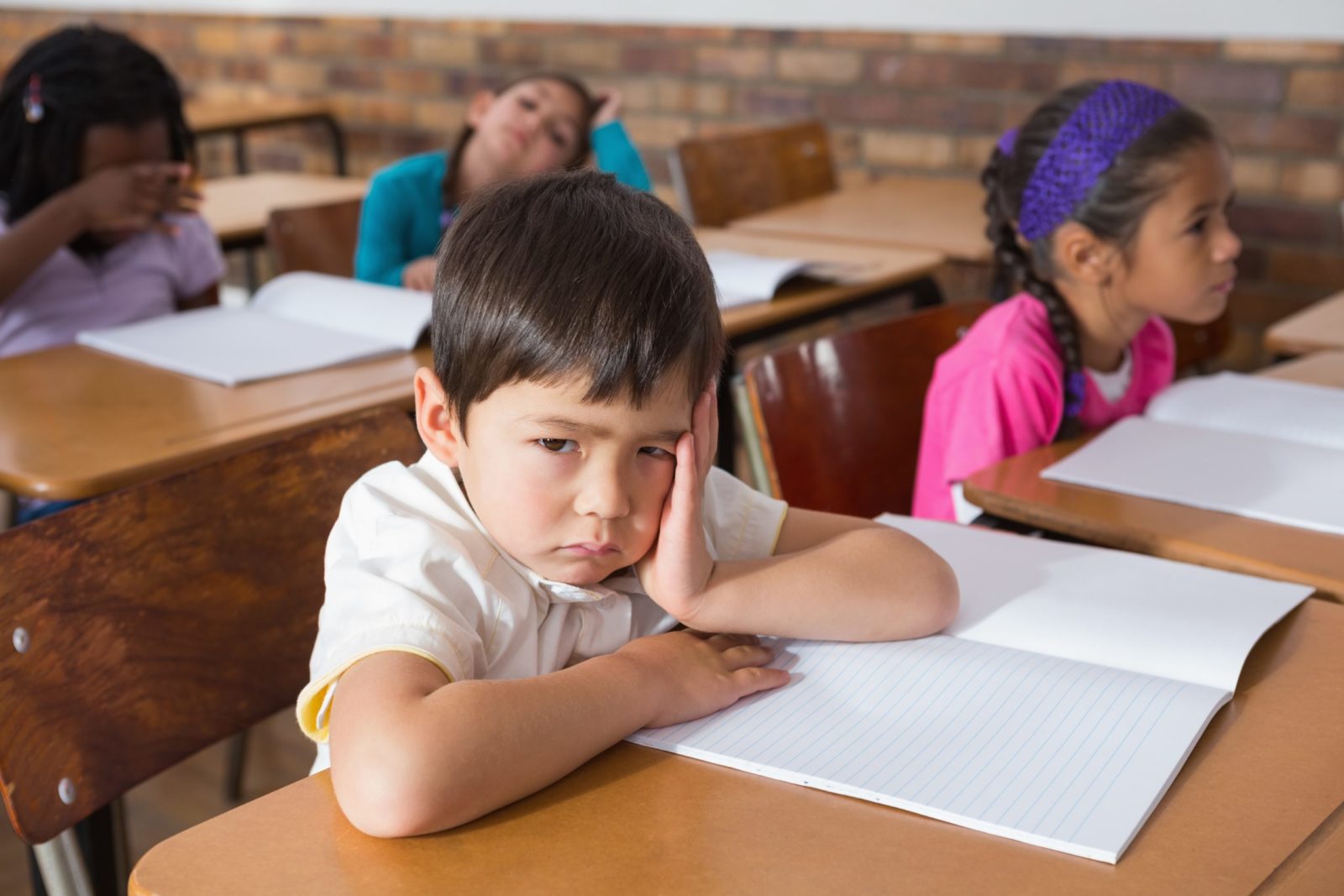 Bored pupil sitting at his desk