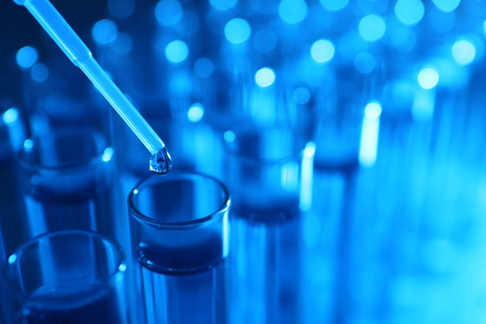 Dripping reagent into test tube with liquid sample, closeup. Laboratory analysis