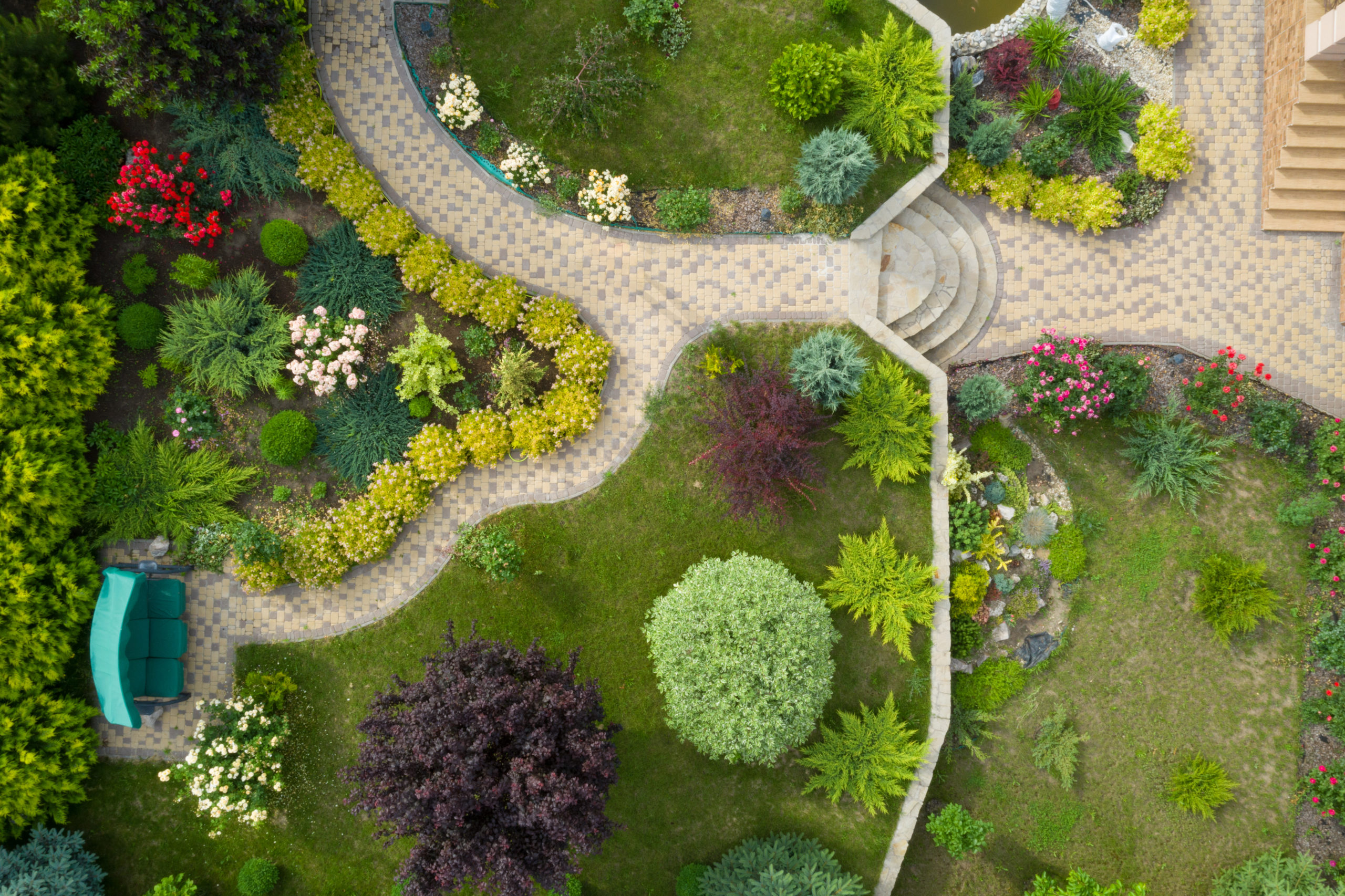 Garden with walkways and green grass. Photo taken from above drone.