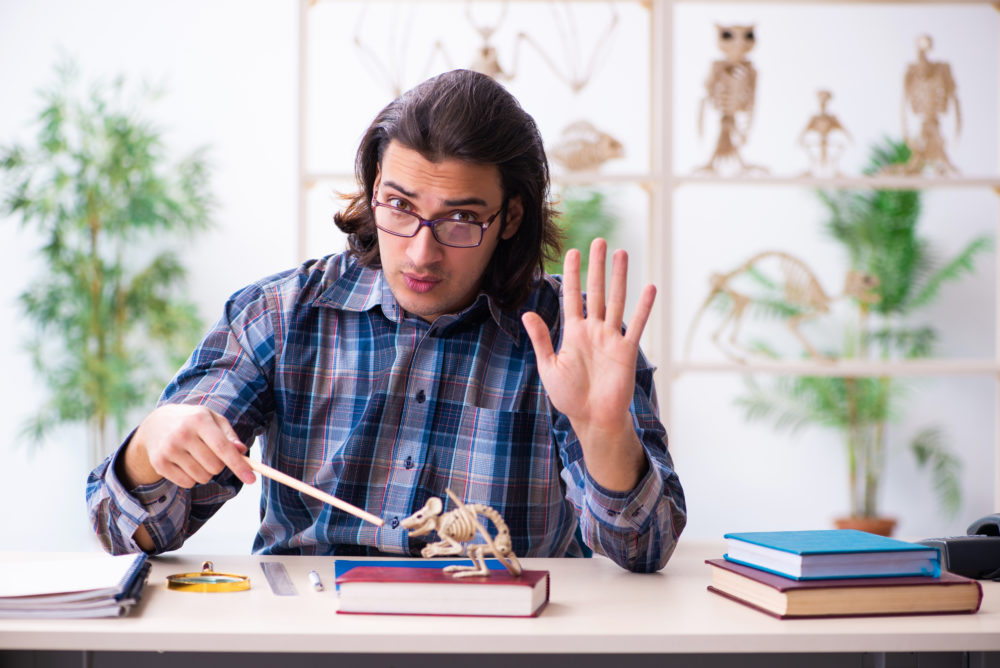 Young male teacher paleontologist in the classroom