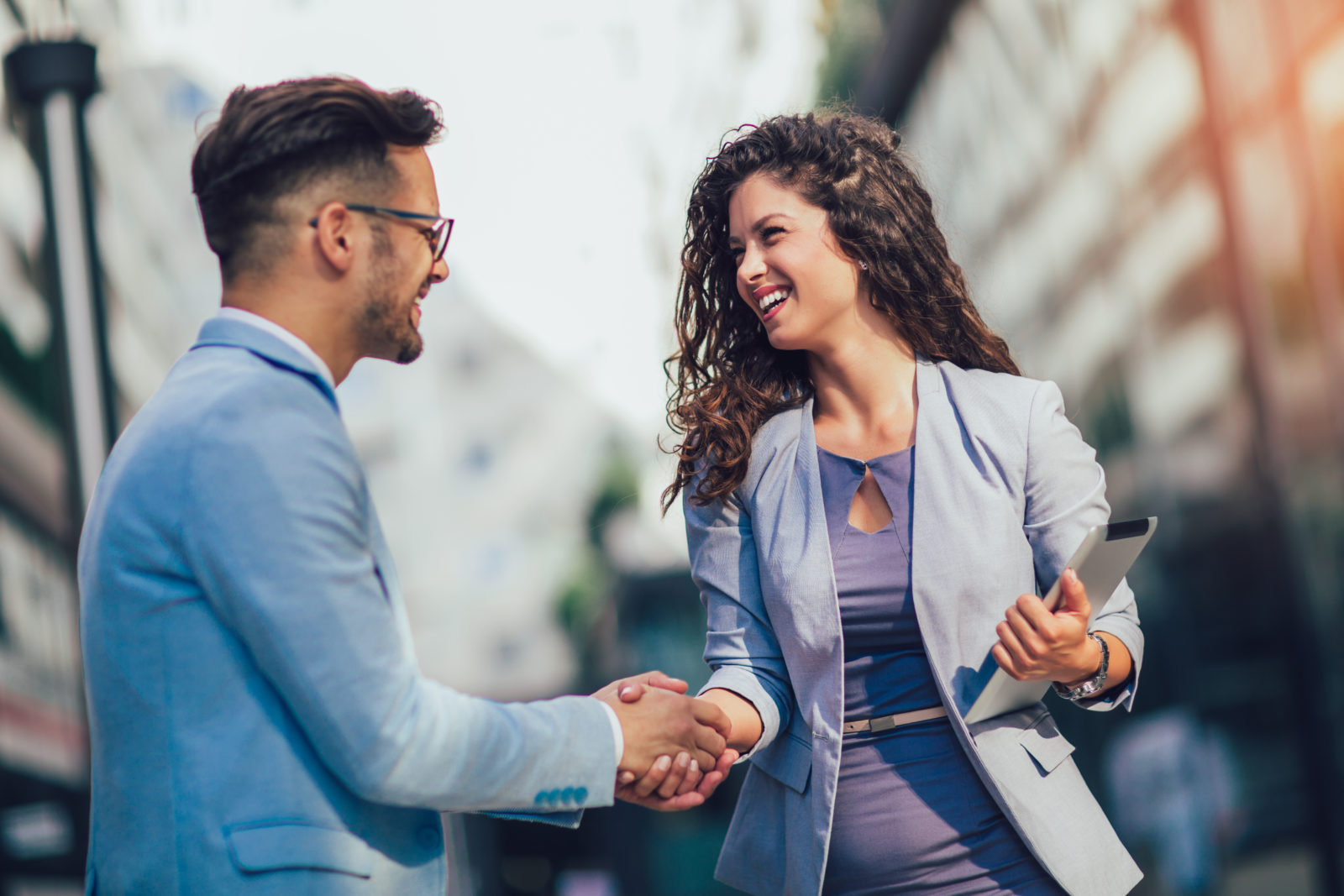 Smiling business colleagues greeting each other outdoors