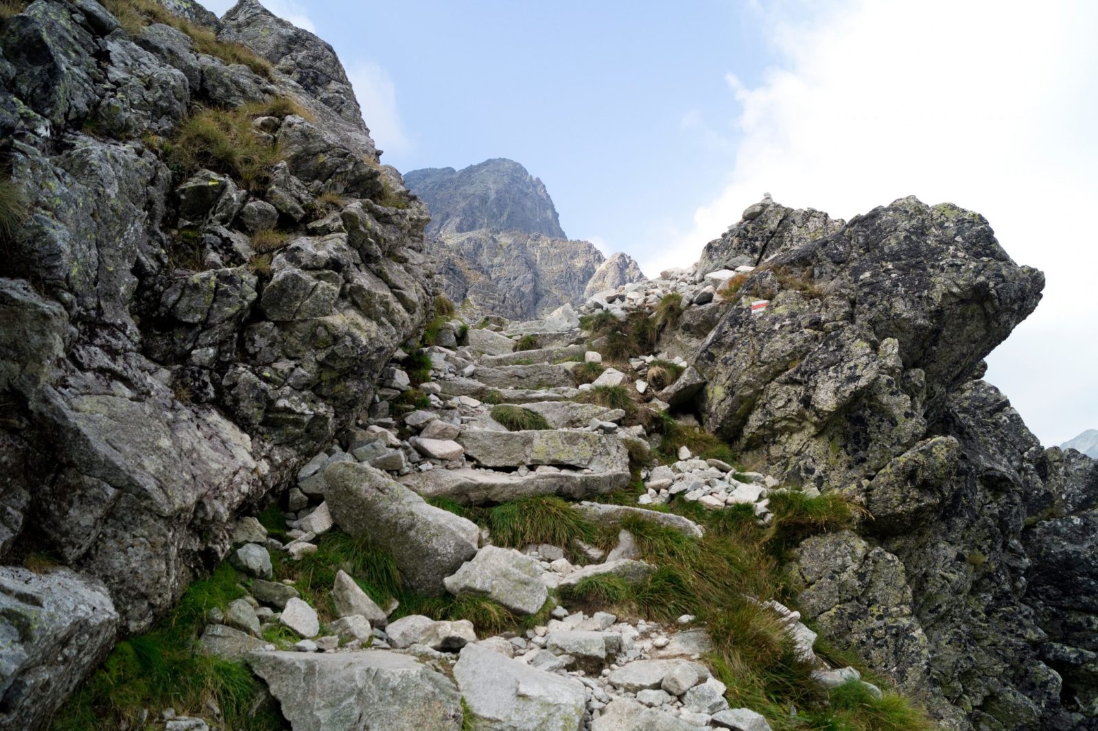 Red marked mountain trail. Stone stairs in difficult rocky terrain. Tatra Mountains. Slovakia