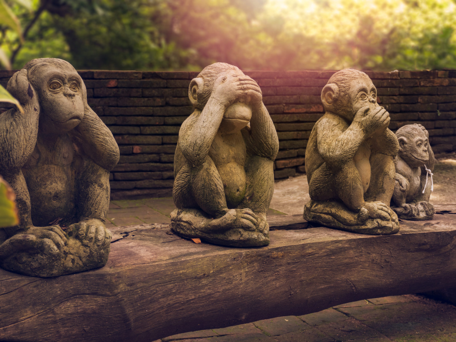 three monkeys statues which have different posts.