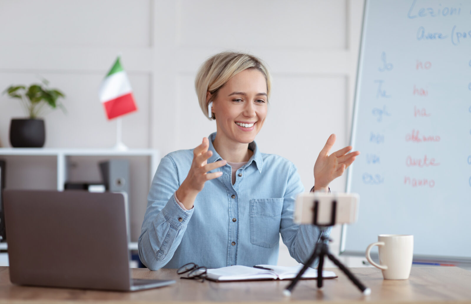 Studying foreign languages remotely. Cheerful female tutor teaching Italian on web, giving online lesson on smartphone