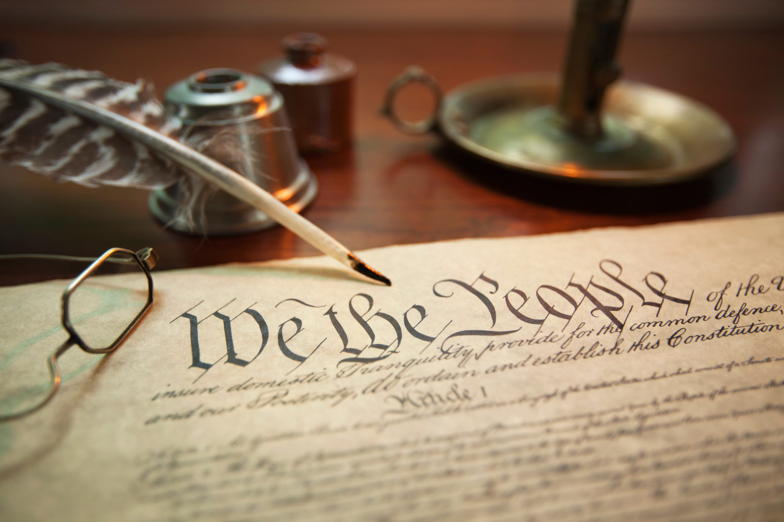 United States Constitution with quill, glasses and candle holder