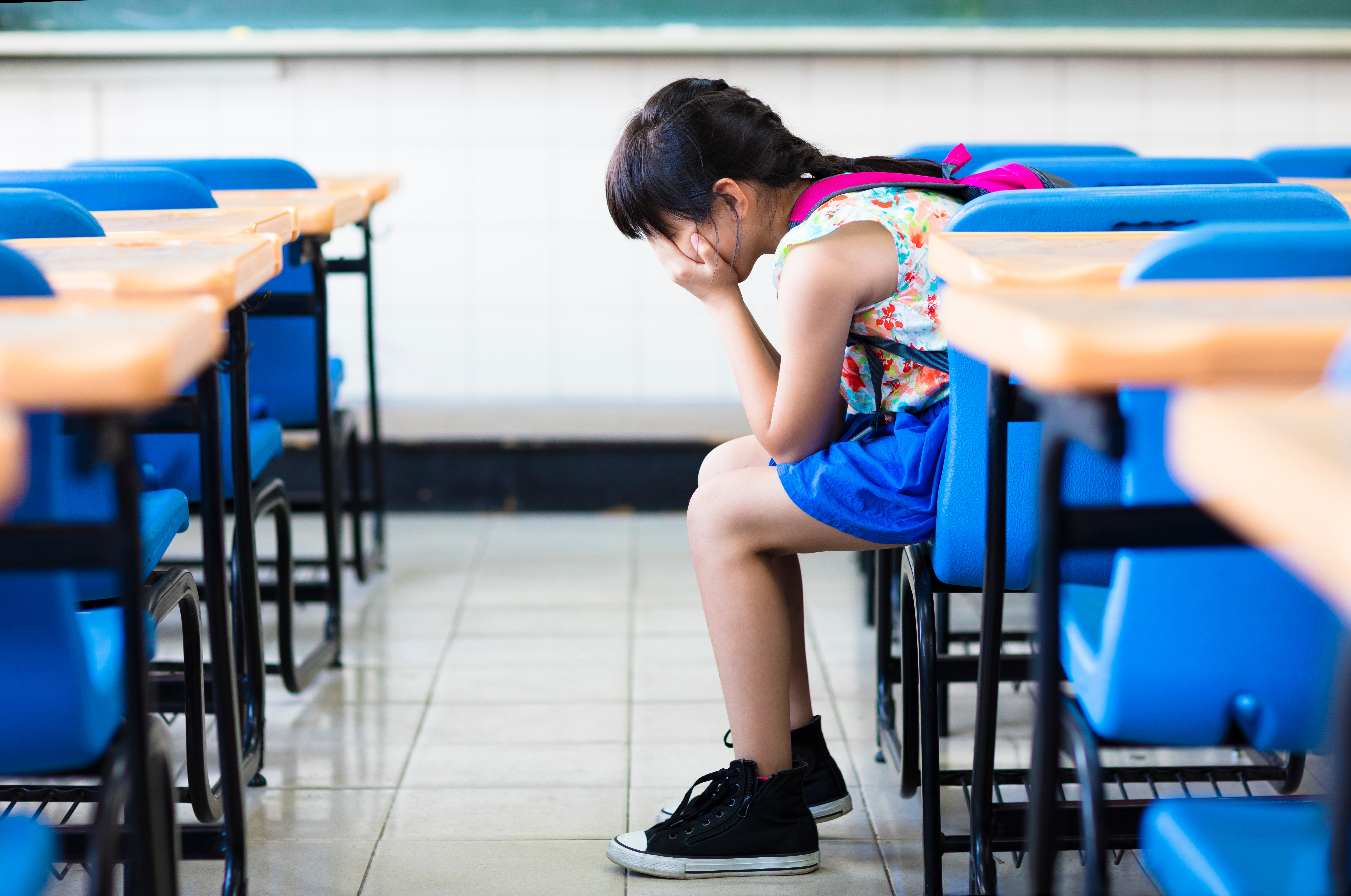 sad girl sitting and thinking in the classroom