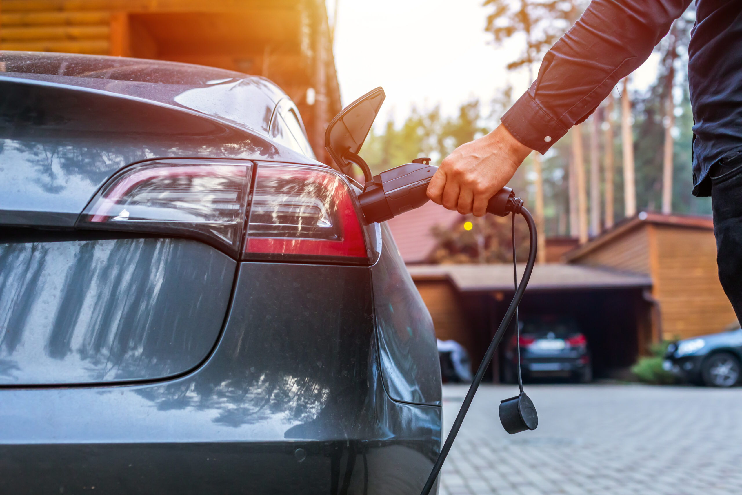 Electric car charging with station, EV fuel advance and modern eco system, Save the earth conception. man connecting a charging cable to a car from an electric car charging station.