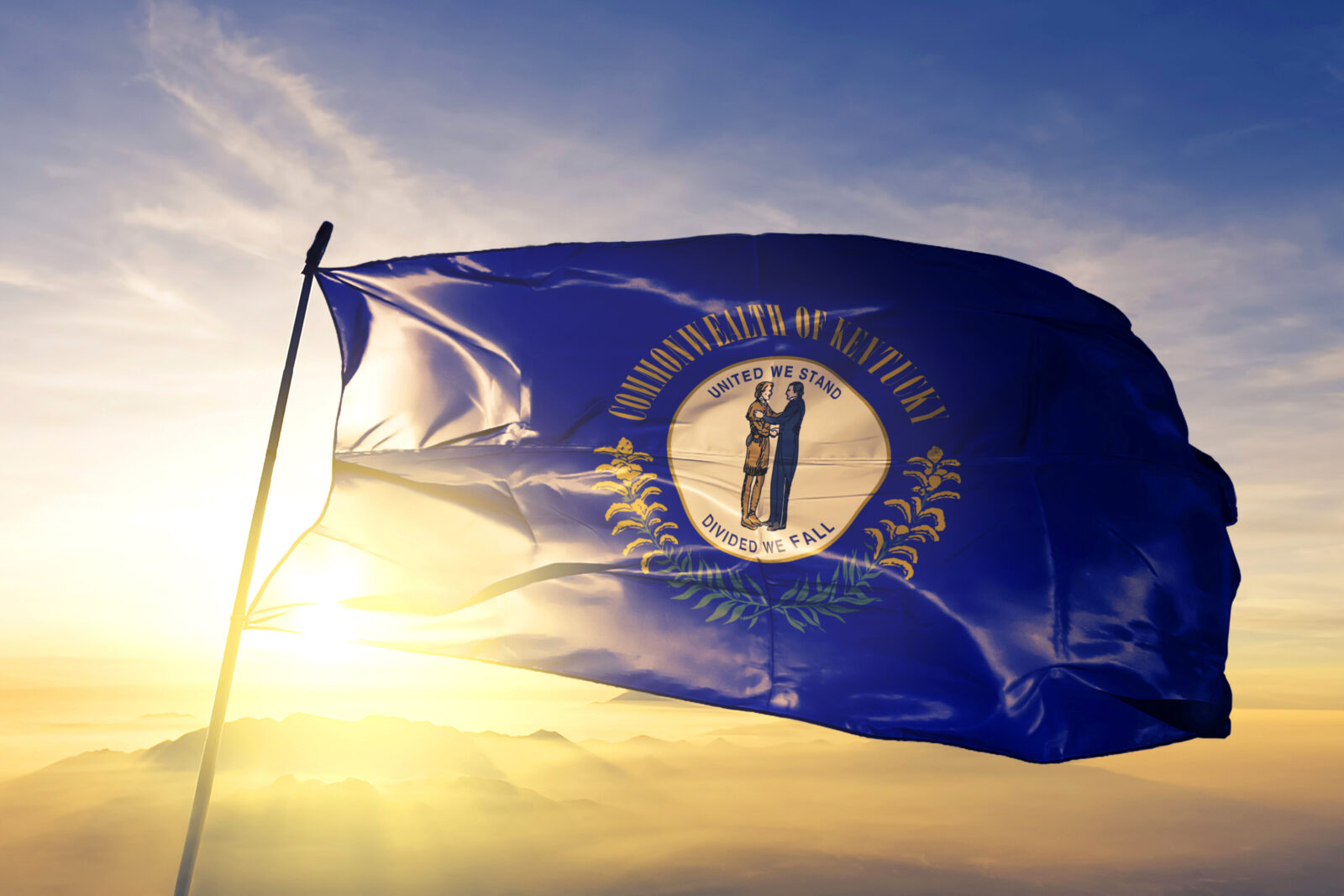 Kentucky state of United States flag waving on the top sunrise mist fog