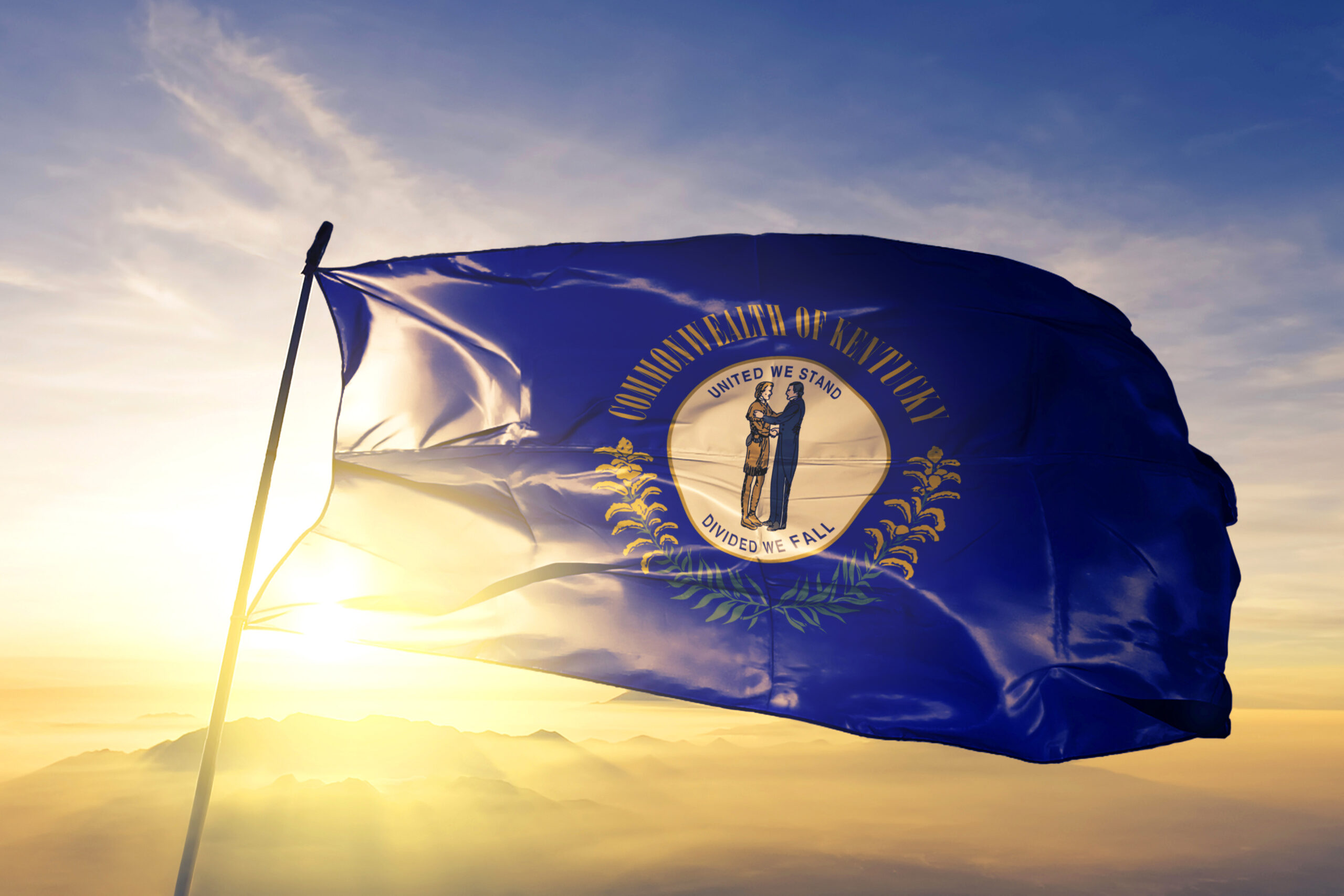Kentucky state of United States flag waving on the top sunrise mist fog