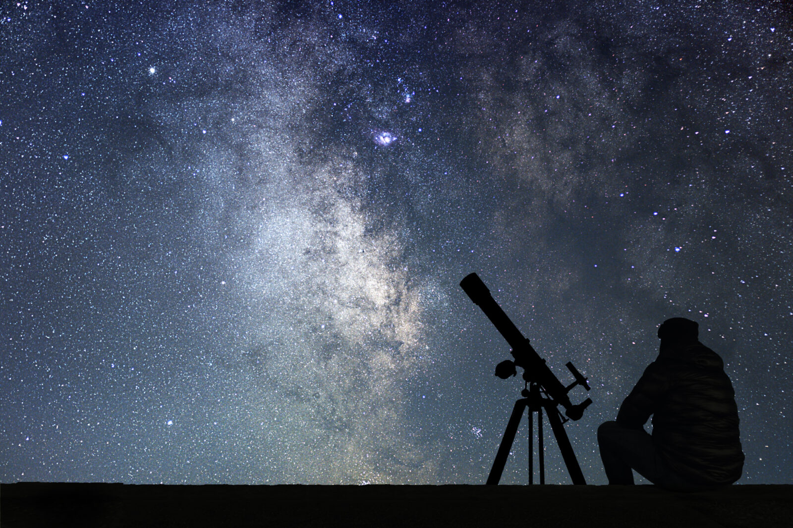 Man with astronomy telescope looking at the stars.