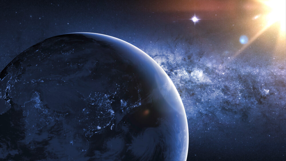 Planet earth planet in deep space against blue nebula and glowing hot sun. Night view from the orbit of the planet with cities lights and distant sun. Elements of this image furnished by NASA.
