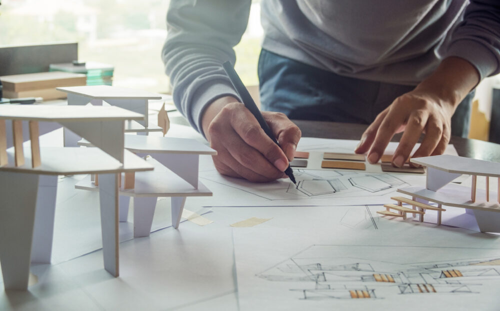 architect design working drawing sketch plans blueprints and making architectural construction model in architect studio
