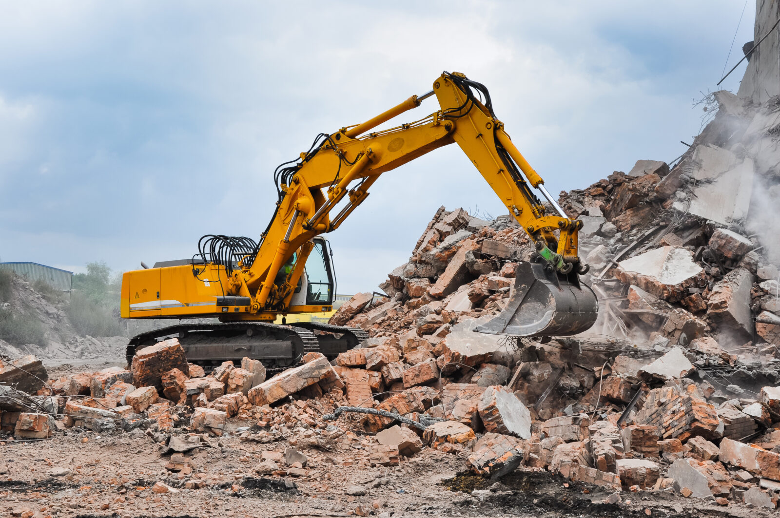 Excavator working at the demolition of an old industrial buildin