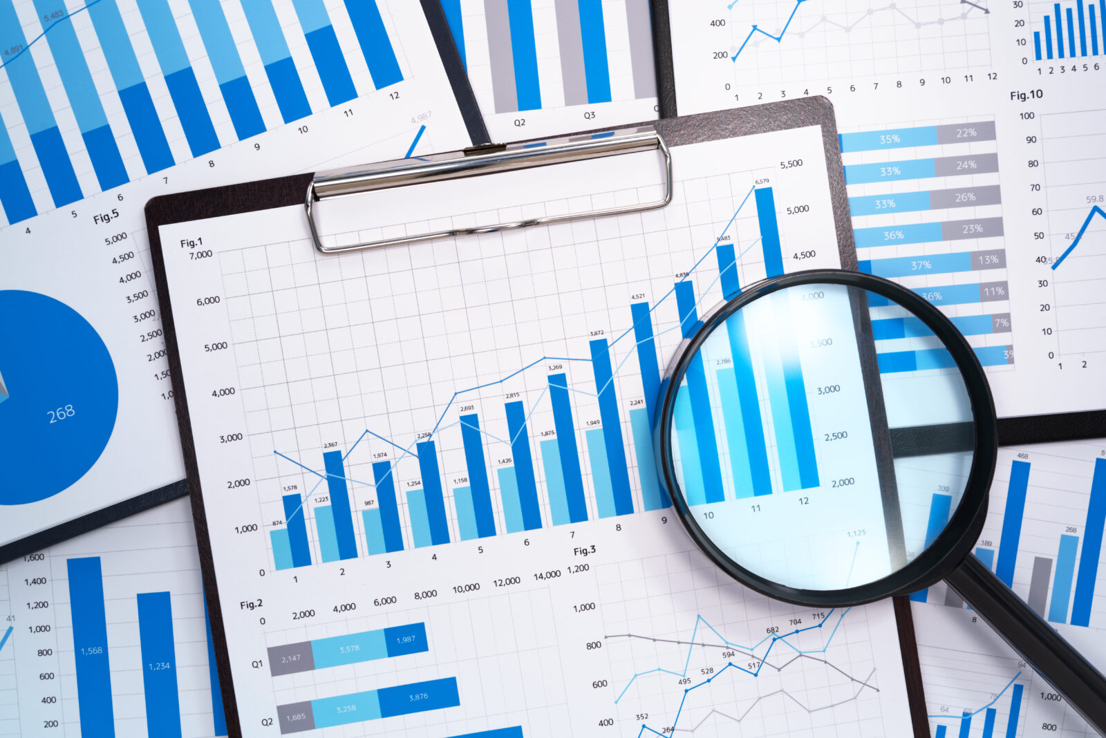 Analyzing and gathering statistical data. Growth charts. Many business reports and magnifying glass.