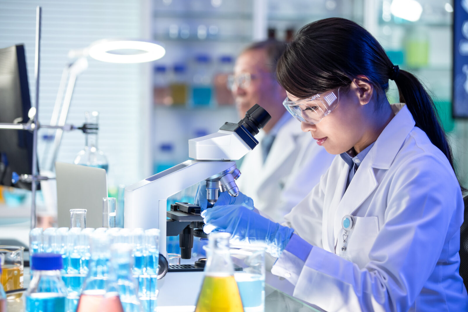 Asian scientist use microscope