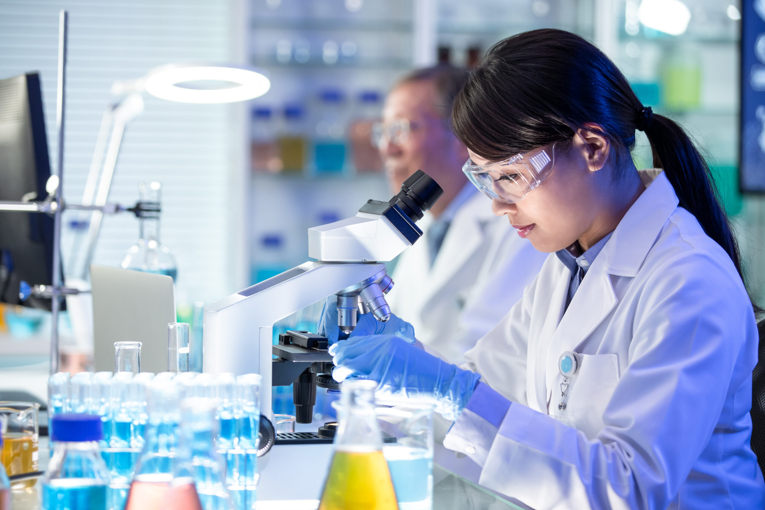 Asian scientist use microscope