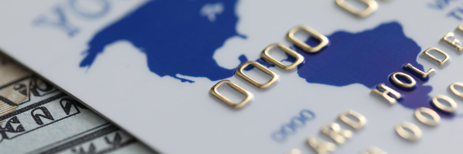 Close-up of credit bank card and currency banknotes on table. Cash and cashless, e-payments process of paying. Finance, insurance and business concept