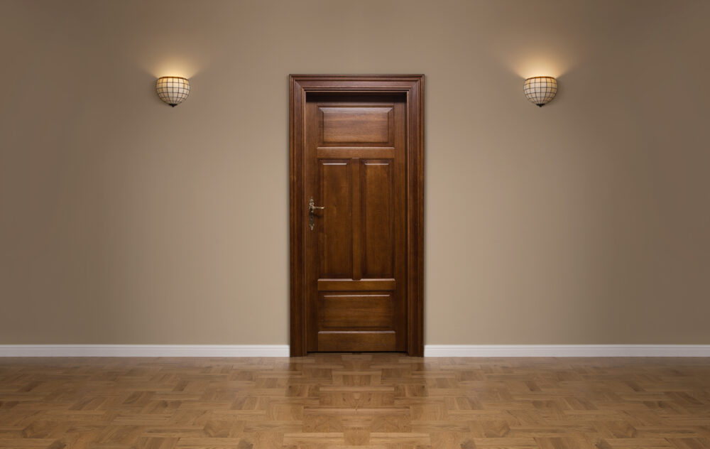 Closed wooden door in the empty room with copy space