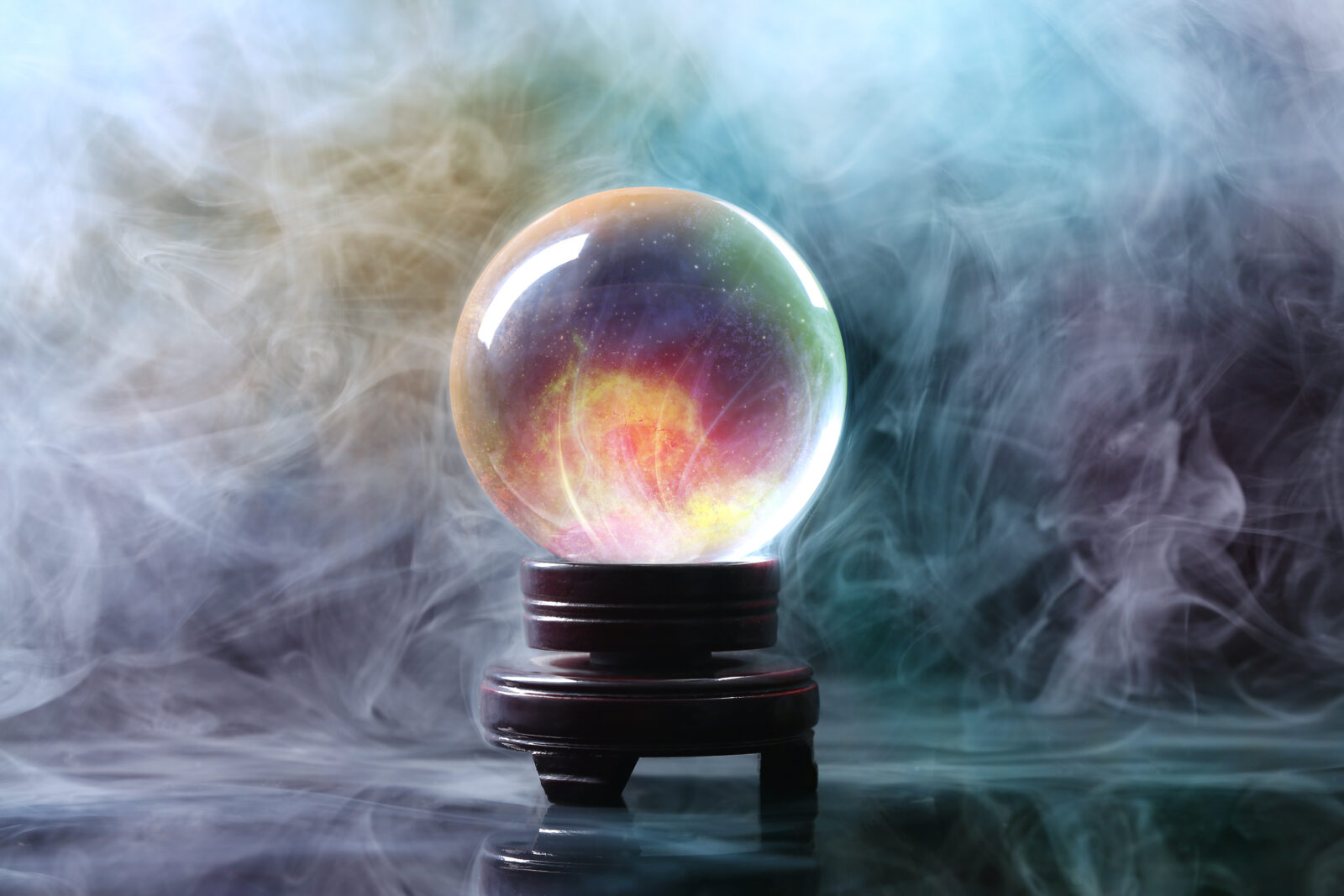 Crystal ball of fortune teller in smoke on table
