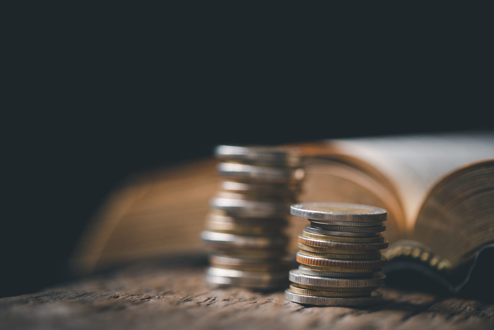 One tenth or tithe is basis on which Bible teaches us to give one tenth of first fruit to God. coins with Holy Bible. Biblical concept of Christian offering, generosity, and giving tithes in church.