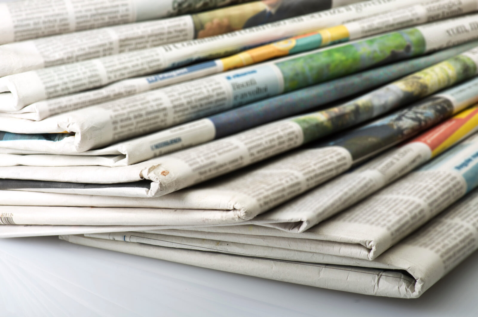 Pile of Various newspapers over white background.