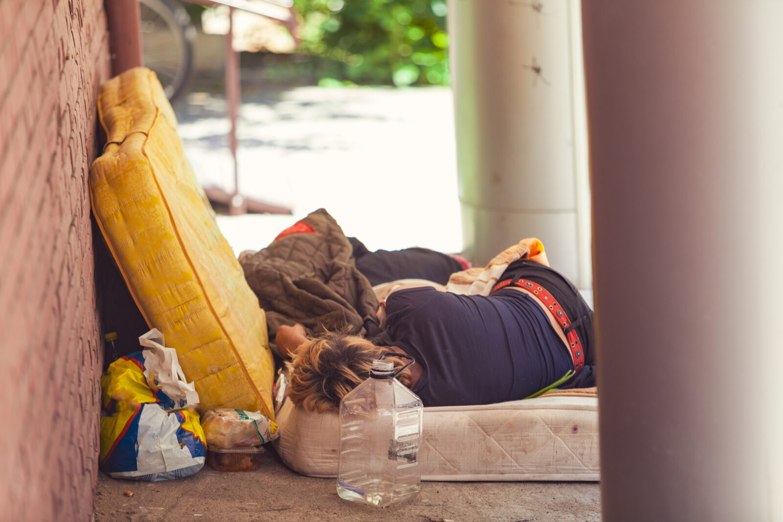 Homeless person sleeping on a mattress