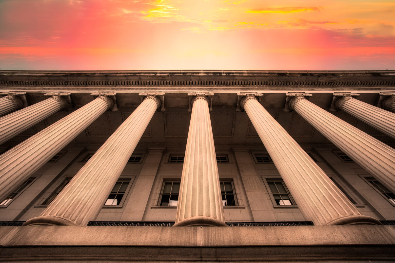 Classical columns on government building with colorful sky