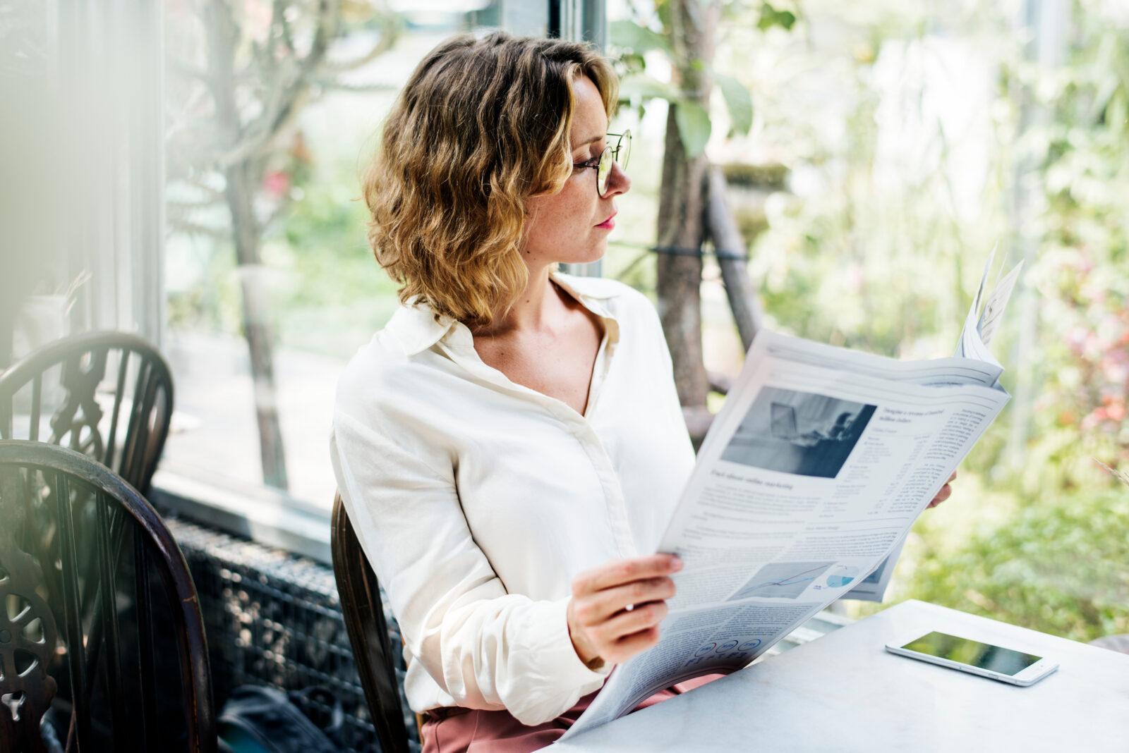 Business woman reading newspaper in the morning