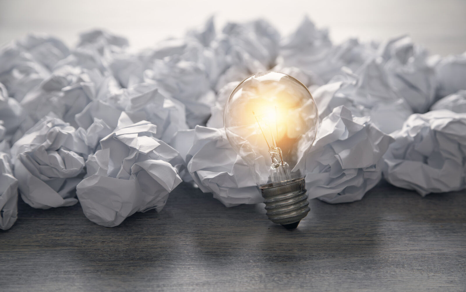 Crumpled paper balls and light bulb.