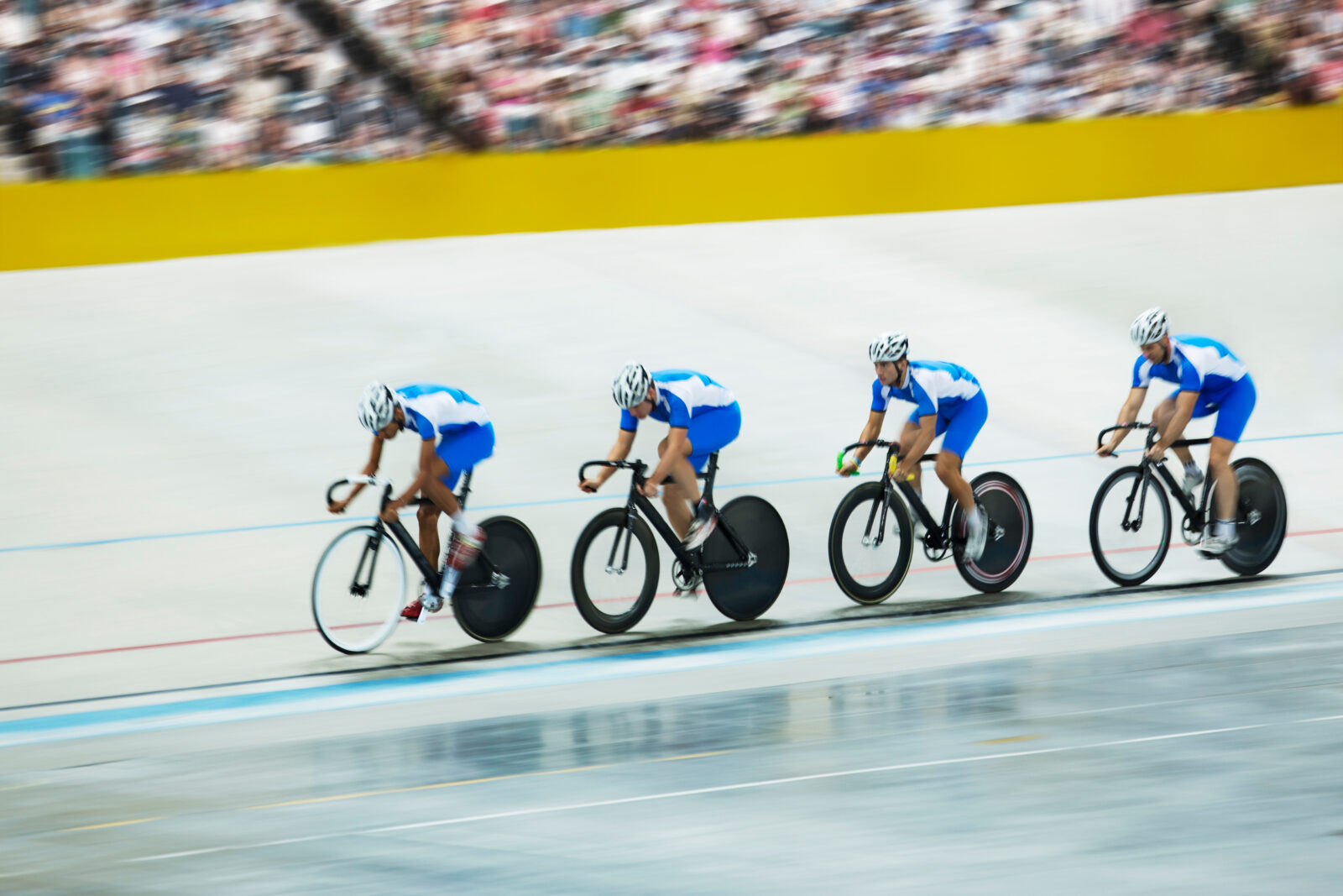 Track cycling team riding around velodrome