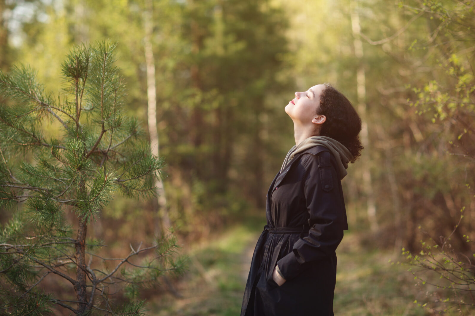 girl woman walking in nature park forest and breathing fresh air. concept of breathing, inhaling, relaxing