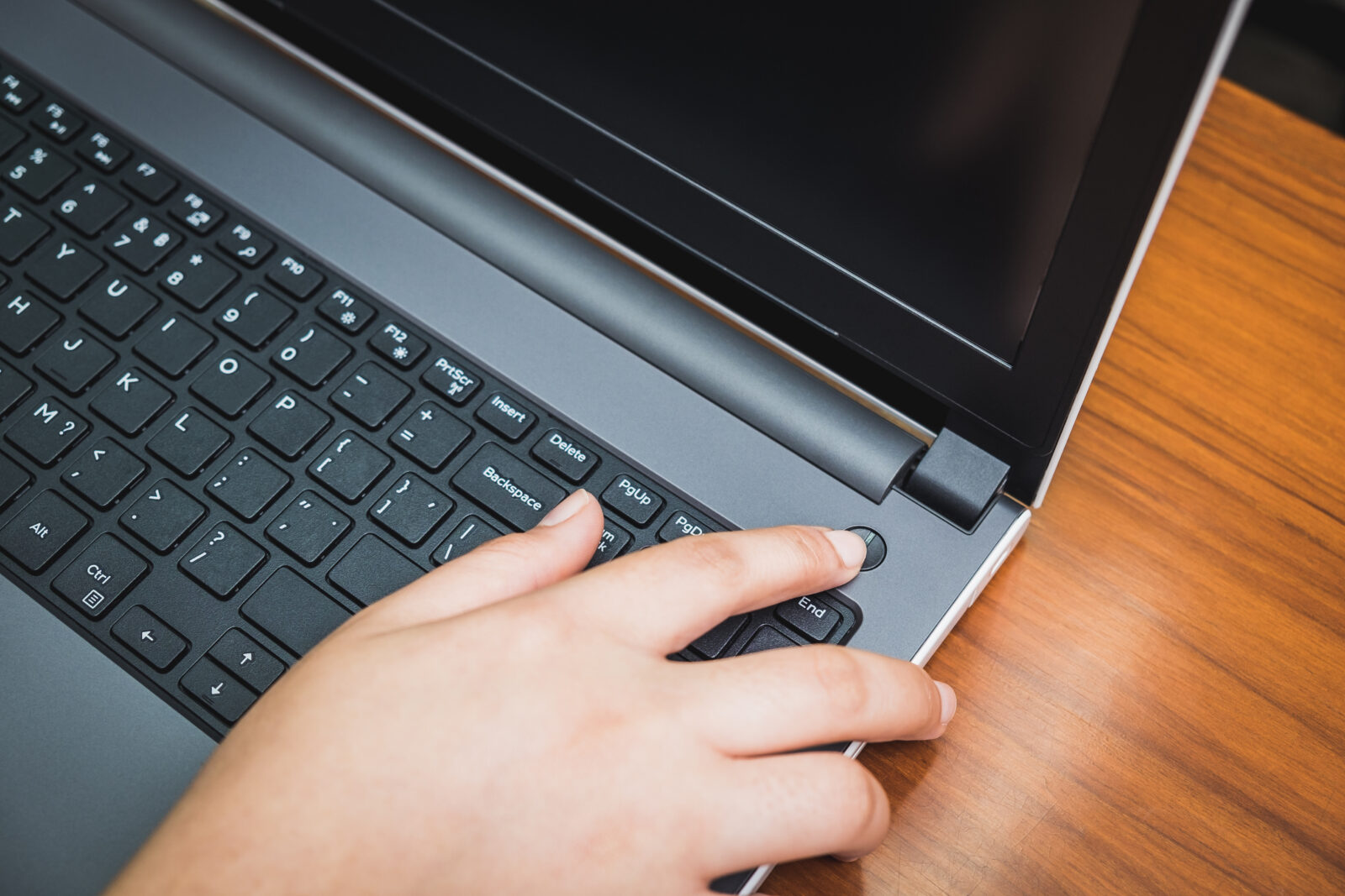 Finger pushing start power button on the laptop computer. Press turn off shutdown keyboard on notebook hardware equipment. Above view with copy space. Technology ban and stop. Social disconnect tablet