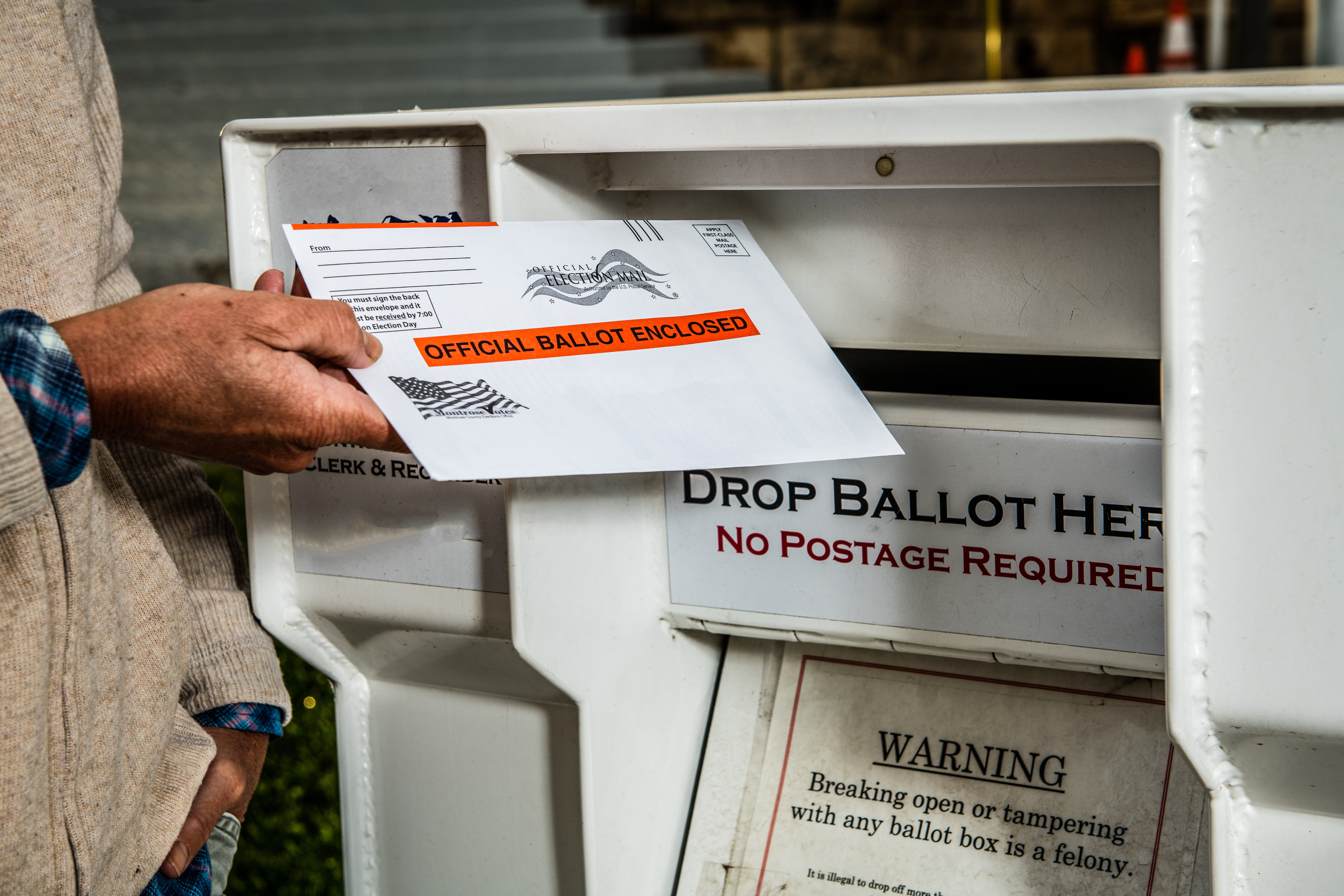 dropping mail-in ballot in ballot box