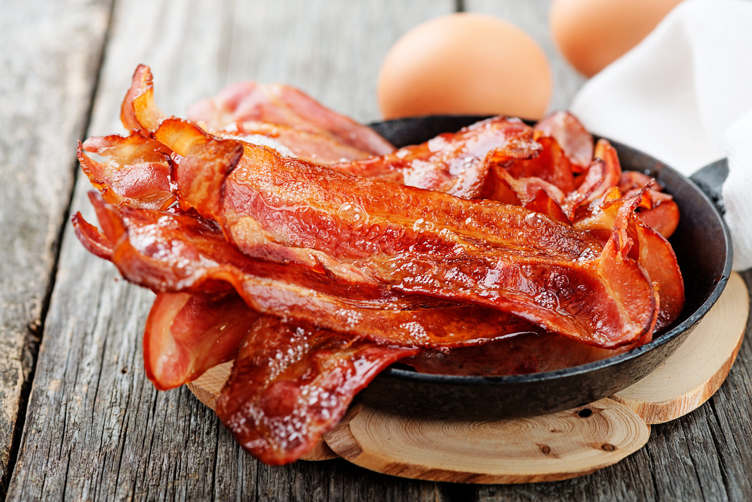 Hot fried bacon pieces in a cast iron skillet.top view