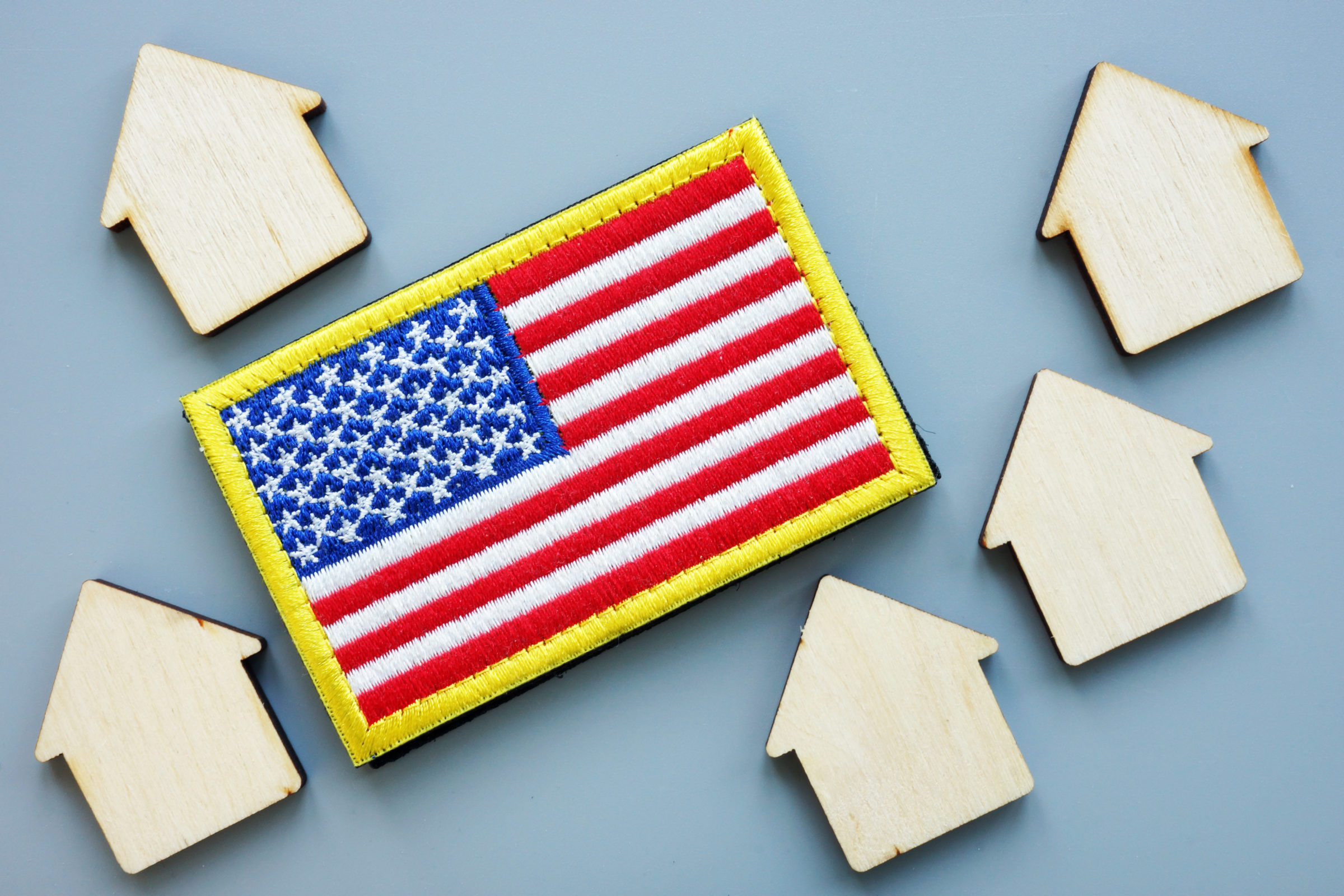 USA flag and models of house. VA direct home loan concept.