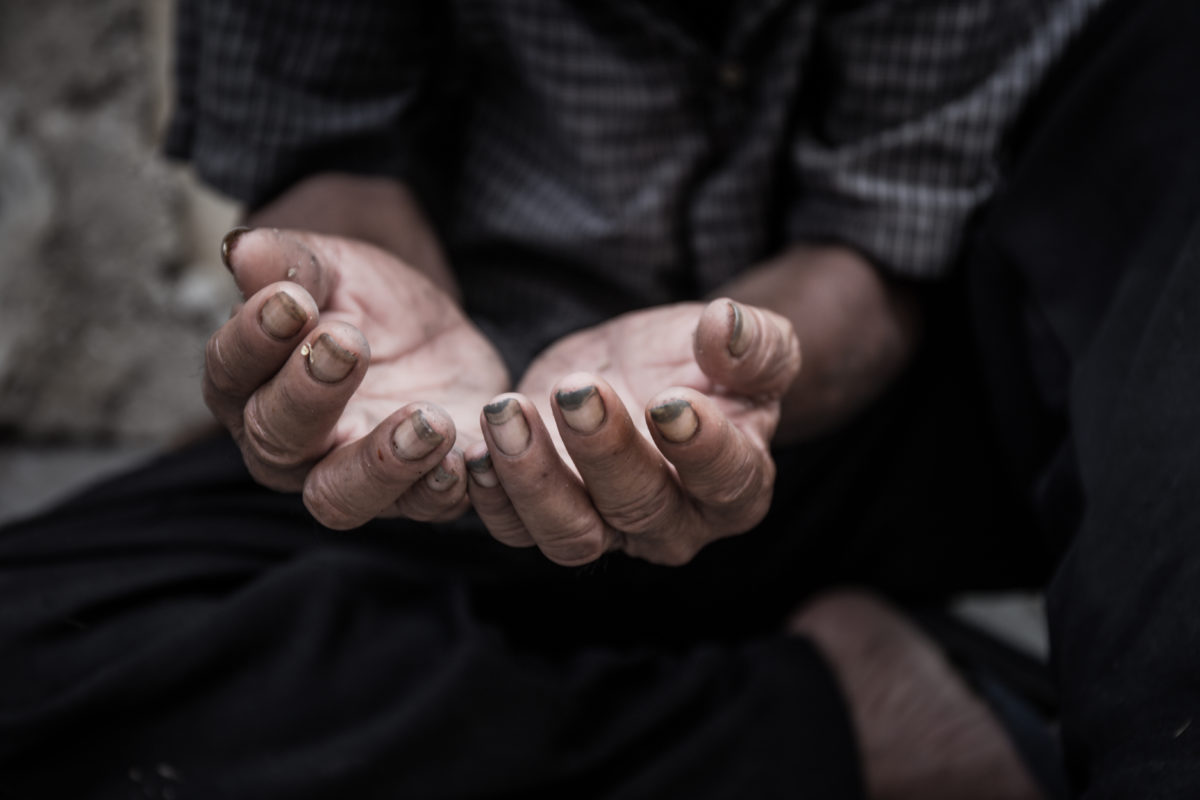 old man beggar begging you for help sitting at dirty slum. concept for poverty or hunger people,human rights,donate and charity for underprivileged children in third world