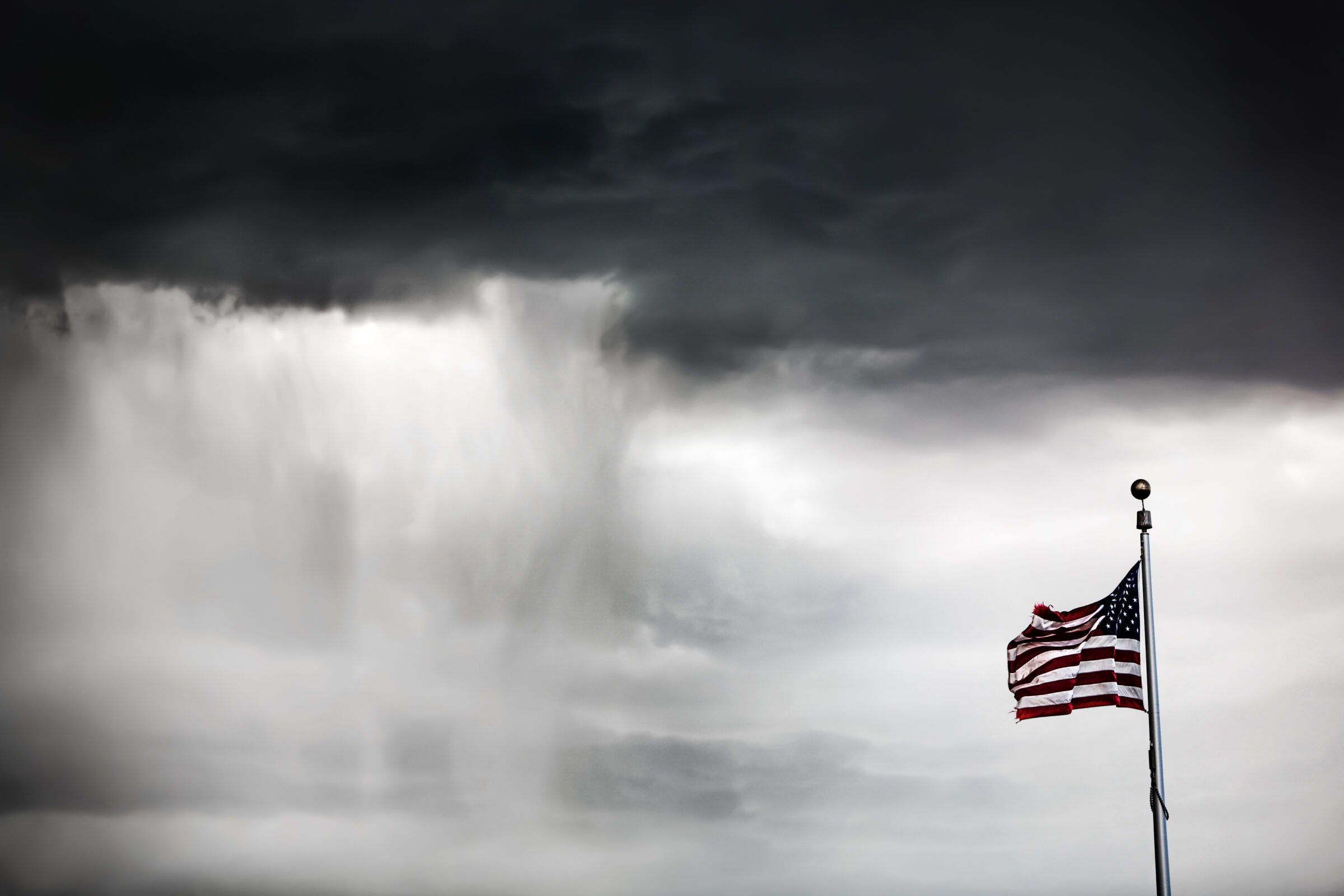 American flag flying during a rain storm