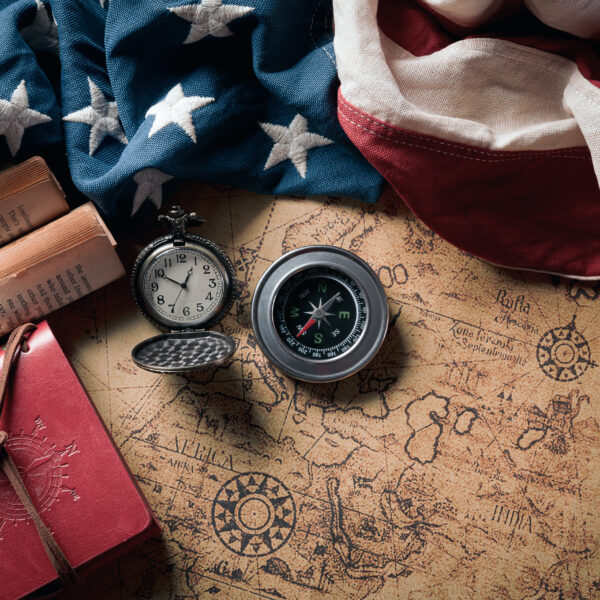 Happy Columbus Day concept. Vintage American flag with compass and retro treasure manuscript. Flat lay, top view with copy space.