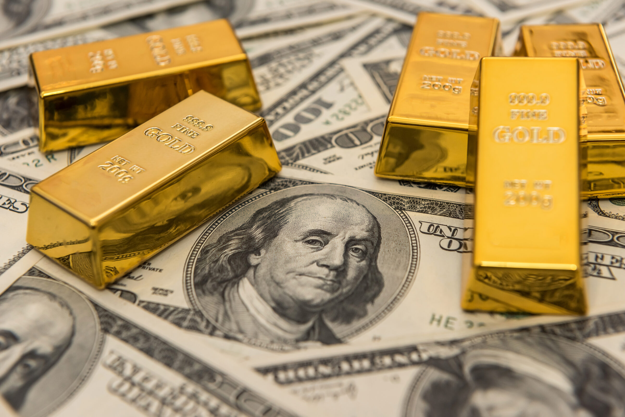 gold bullion bars on usd money bills. Success concept