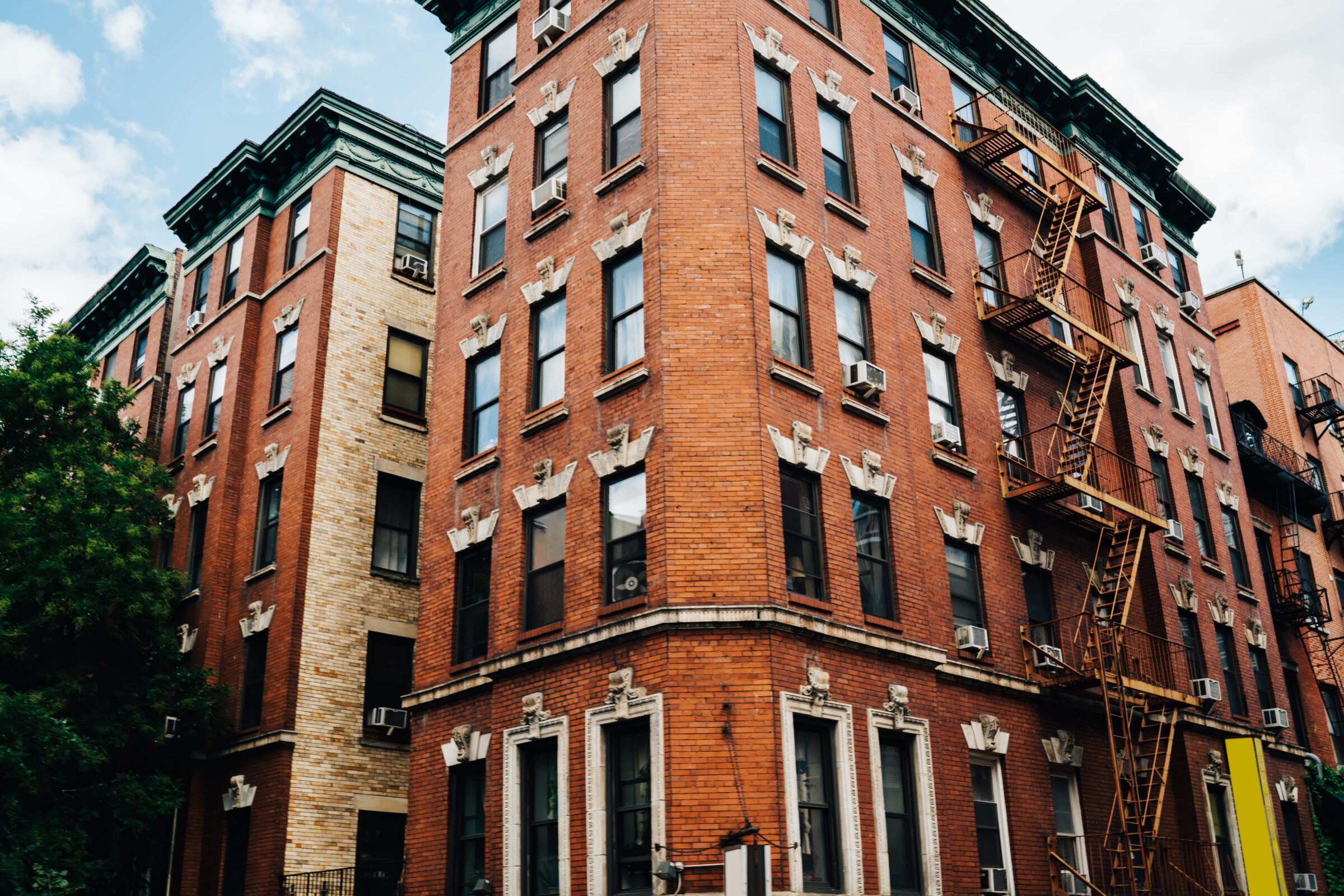 Tall vintage building with expensive apartment for rent located in brooklyn district, red stone urban architecture construction exterior with windows for residence housing on old historical street .