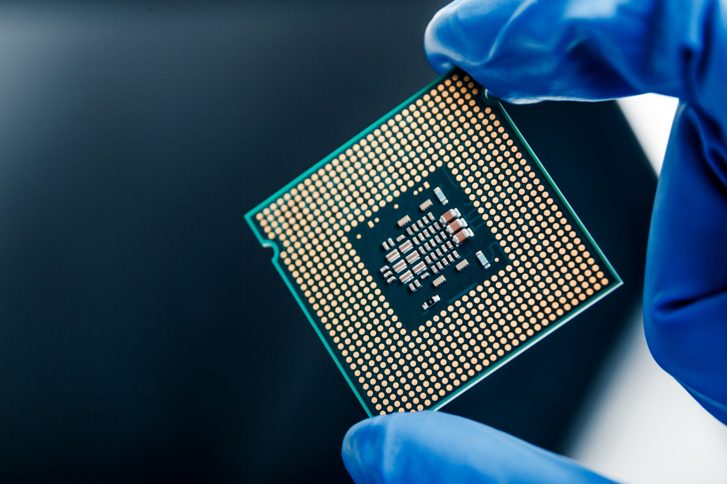 Close-up view on a new semiconductor microchip in gloved hand of computer scientist. Modern technology and hardware development
