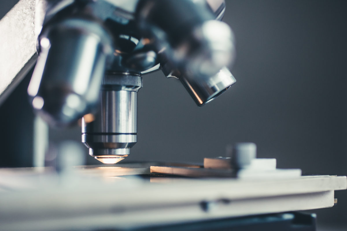 Close-up shot of microscope with metal lens at laboratory.