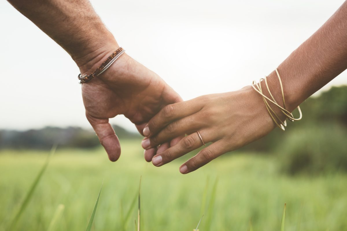 Loving couple holding hands in a field