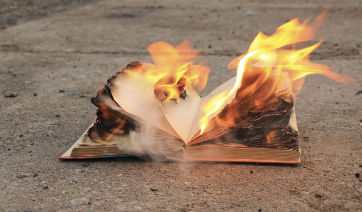 book with burning pages on a concrete surface
