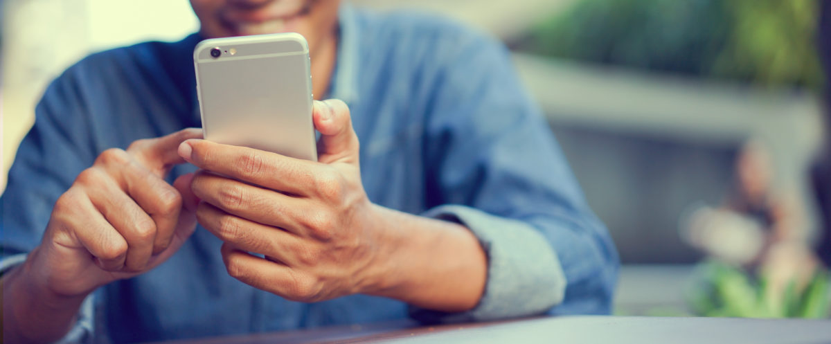 close up hand hold mobile cell phone device:focus on man play on smartphone concept